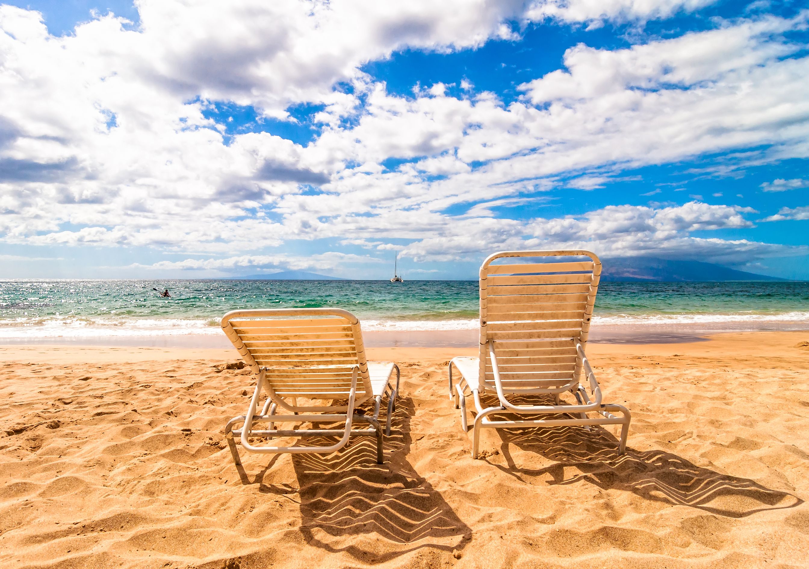 Two beach chairs on golden Maui sand facing turquoise ocean